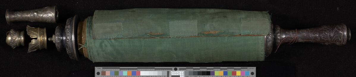 Rolled scroll — green silk backing, wooden handle, and metal finials · no indexed biblical text, Manchester Hebrew MS 11 (Esther Scroll)